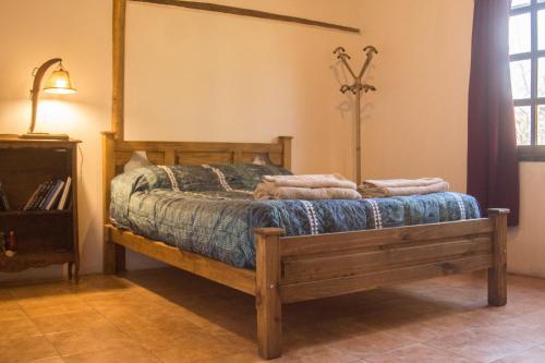 a bedroom with a wooden bed with towels on it at Casa Rural entre Bodegas y Viñedos ' El Jarillal" in La Consulta