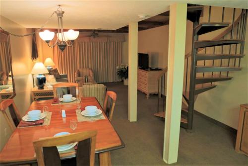 a dining room with a table and a spiral staircase at Royal Holiday Beach Resort in Biloxi