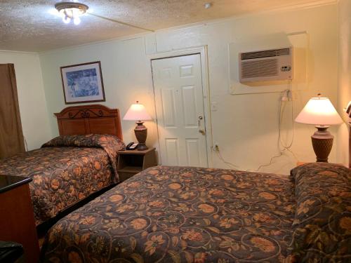 a hotel room with two beds and two lamps at Economy inn in Bay City