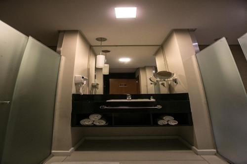 a bathroom with a sink and a mirror at Hotel Amantykir in Itajubá