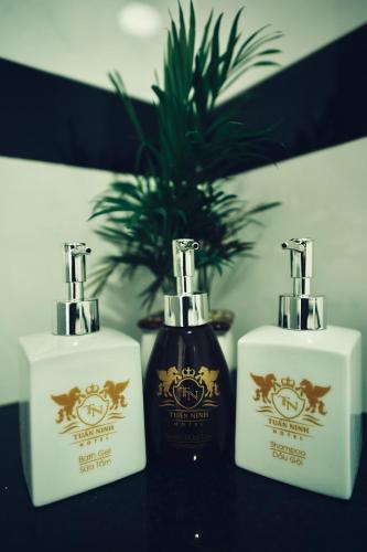three bottles of soap on a table with a plant at Tuấn Ninh Hotel I in Con Dao