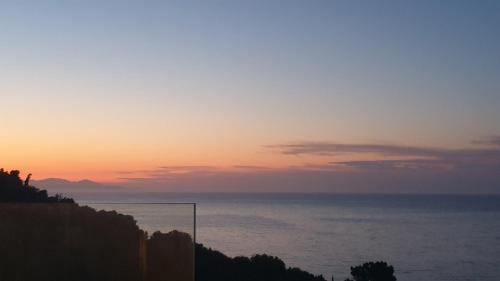 a sunset over the ocean on a cliff at Zante Fiore Suites in Xirokástellon