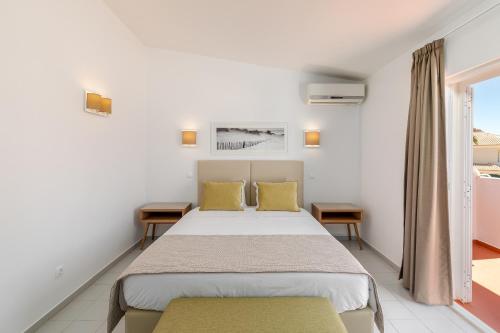 a bedroom with a large bed with yellow pillows at Moradias Villas Joinal in Albufeira