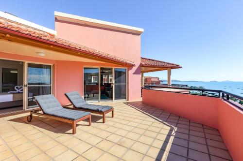 a house with a patio with two chairs on a balcony at Martinique Whitsunday Resort in Airlie Beach