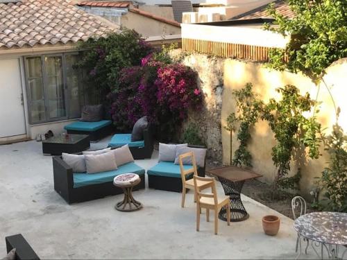 a patio with a couch and chairs and a table at Pitibi Maison d'Hote in Sanary-sur-Mer