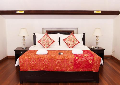 a bedroom with a large bed with two lamps at Heeren Straits Hotel in Melaka