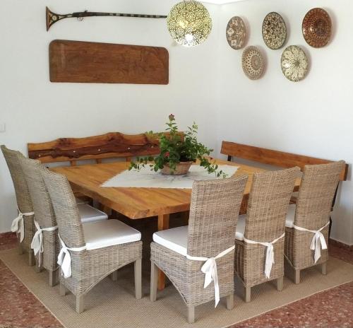 a dining room with a wooden table and chairs at Beach and Tennis in Sant Josep de Sa Talaia