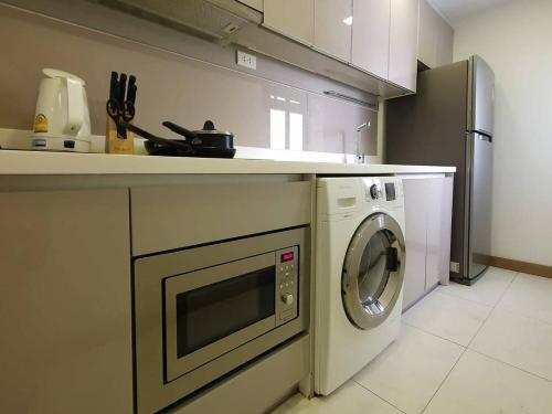 a kitchen with a washing machine under a counter at 18 Residence in Bangkok