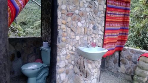 a stone bathroom with a sink and a toilet at Finca de la Vaca - Family House in Mera