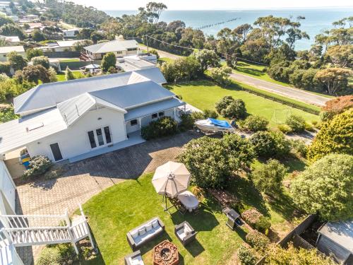an aerial view of a white house with a yard at Bridport Beach House in Bridport