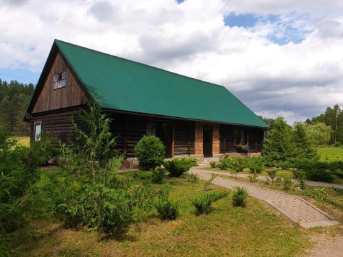 a large wooden barn with a green roof at Gliemji in Krāslava