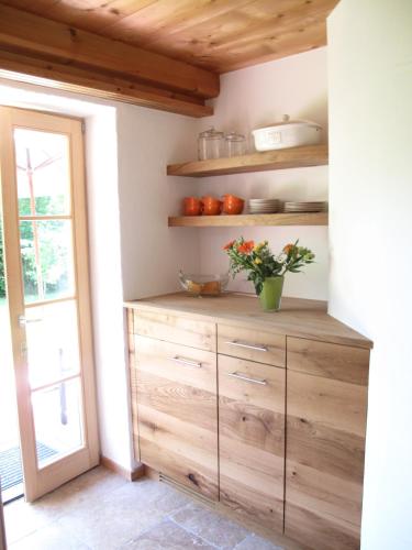 a kitchen with a wooden dresser with a plant on it at Landhaus Am Arzbach in Bad Tölz