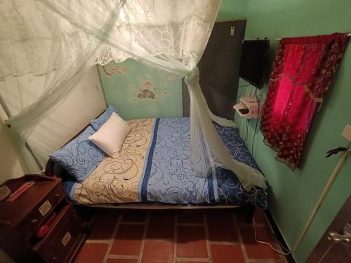 a small bedroom with a bed with a canopy at 彼岸古厝民宿-包棟優先--Biiann B&B in Jinning