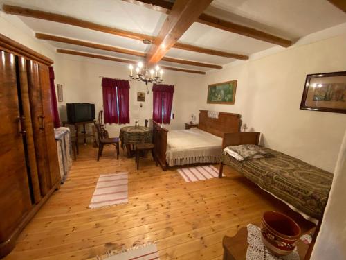 ein Schlafzimmer mit einem Bett und ein Wohnzimmer in der Unterkunft Kolokán vendégház in Sarud