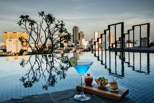 una bebida en una bandeja al borde de una piscina en PATIO Hotel & Urban Resort en Phnom Penh
