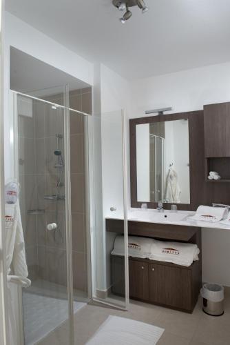 une salle de bain avec une douche, un lavabo et un miroir dans l'établissement Domitys Le Pont des Lumières, à Lyon