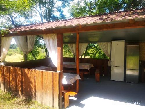 einem Holzpavillon mit einem Bett und einem Tisch in der Unterkunft Fiesta in Solotwyno