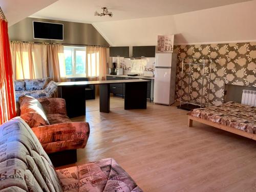 a living room with a couch and a kitchen at Апартаменты Жить просто in Pyatigorsk