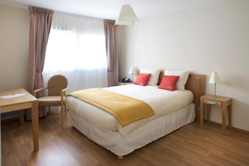 奧泰茲的住宿－Domitys Les Clés d'Or，一间卧室配有一张带红色枕头的大床