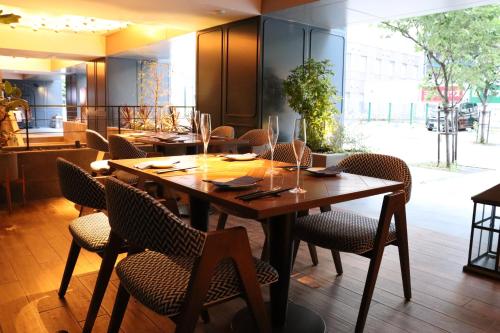 a dining room with a wooden table and chairs at THE LIVELY FUKUOKA HAKATA in Fukuoka