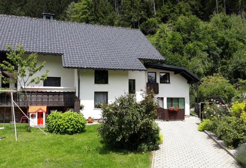 ein weißes Haus mit schwarzem Dach in der Unterkunft Apartment Jakelj in Kranjska Gora