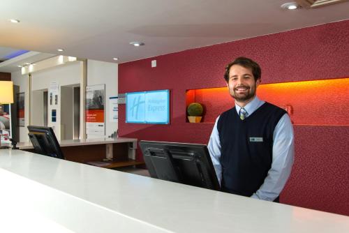 a man standing at a counter in an office at Holiday Inn Express Stevenage, an IHG Hotel in Stevenage