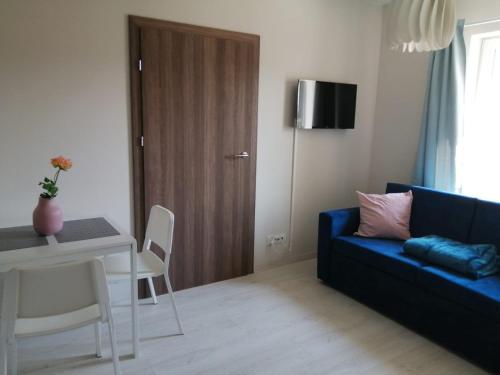 a living room with a blue couch and a table at APARTAMENTY POSEJDON in Świnoujście