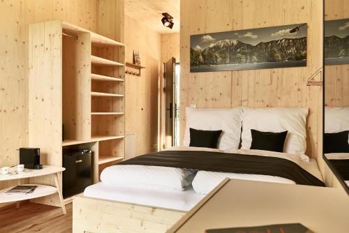 ein Schlafzimmer mit einem Bett in einem Zimmer mit Holzwänden in der Unterkunft Water, Ski & Mountain Lodge in Kiefersfelden