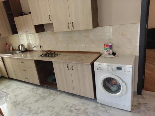 a kitchen with a washing machine and a counter at AZAT НОМЕ in Tbilisi City