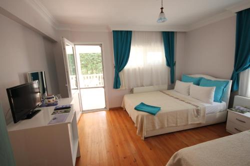 pokój hotelowy z 2 łóżkami i telewizorem w obiekcie Cunda Aşiyan Otel w mieście Ayvalık