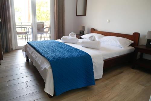 a bedroom with a large bed with towels on it at The Kitehouse Apartments in Eleonas
