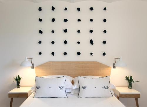 a bedroom with a white bed with two white pillows at Locanda Rossa in Capalbio