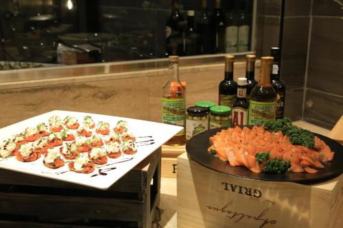 two plates of food on a counter with bottles of wine at Ramada by Wyndham Seoul Sindorim in Seoul