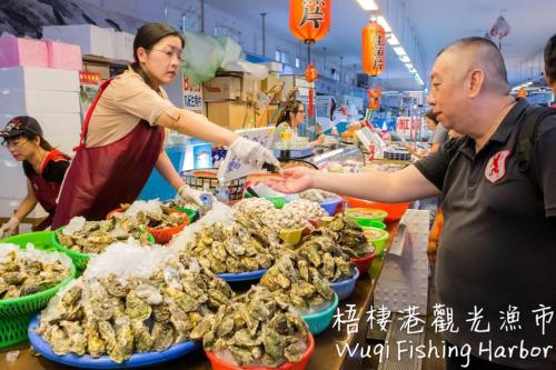 um homem e uma mulher a preparar comida num mercado em Backpacker 41 Hostel - Taichung em Taichung