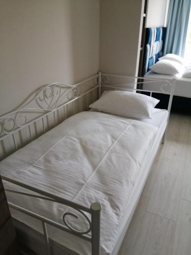a bed with white sheets and pillows in a room at APARTAMENTY POSEJDON in Świnoujście