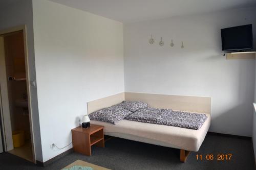 een slaapkamer met een bed en een tv aan de muur bij Aga Pokoje Gościnne - Tylko dla dorosłych in Rewal