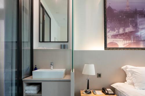 baño con lavabo, cama y espejo en Wifi Boutique Hotel en Hong Kong