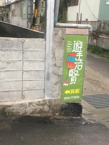 a sign is posted on the side of a building at Yu Shou Hao Hsien Guesthouse in Fushi