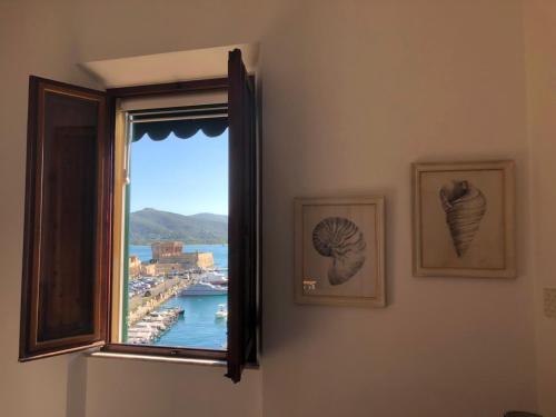 a room with a window with a view of a harbor at Le Stanze sul Mare in Portoferraio