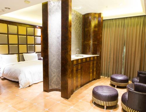 a bedroom with a bed and a sink and chairs at All-Ur Boutique Motel - KaoHsiung Branch in Kaohsiung