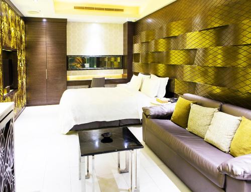 a hotel room with a bed and a couch at All-Ur Boutique Motel - KaoHsiung Branch in Kaohsiung