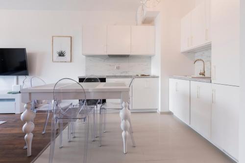 a kitchen with white cabinets and a table and chairs at Symphony Baltica Towers Apartamenty in Gdańsk