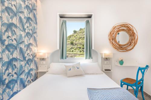 1 dormitorio con cama, ventana y silla en La Torretta Lodge, en Manarola