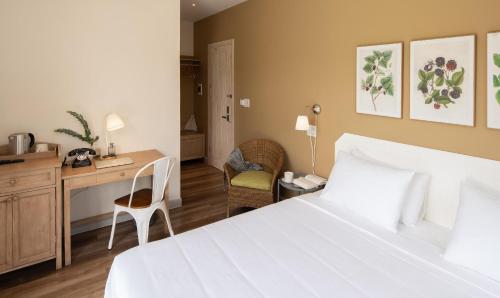 a hotel room with a bed and a desk and chair at La Em Boutique Villa in Da Lat