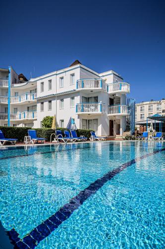 a large swimming pool in front of a building at Sunset Village in Didim