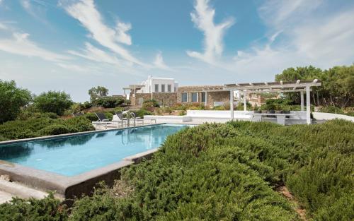 a swimming pool in the yard of a house at Mykonos Unique Villas in Kalafatis
