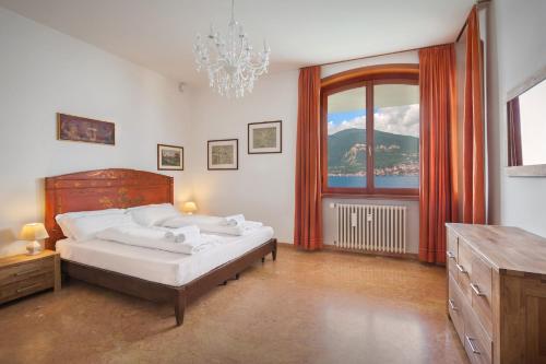 um quarto com uma cama e uma grande janela em Villa Francesca-Grande appartamento in riva al lago em Brenzone sul Garda