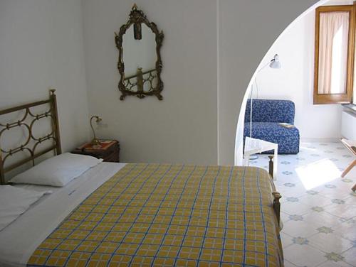 
a bedroom with a bed, chair, mirror, and window at Villa Casale Ravello Residence in Ravello
