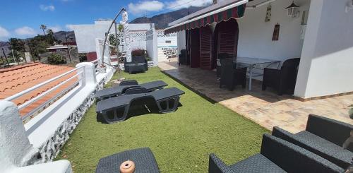 a backyard with a table and chairs and grass at Casitas Las Pereras in Los Llanos de Aridane