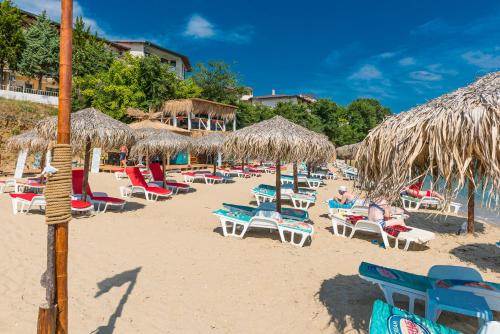 a group of chairs and umbrellas on a beach at Iris Beach Hotel in Sveti Vlas